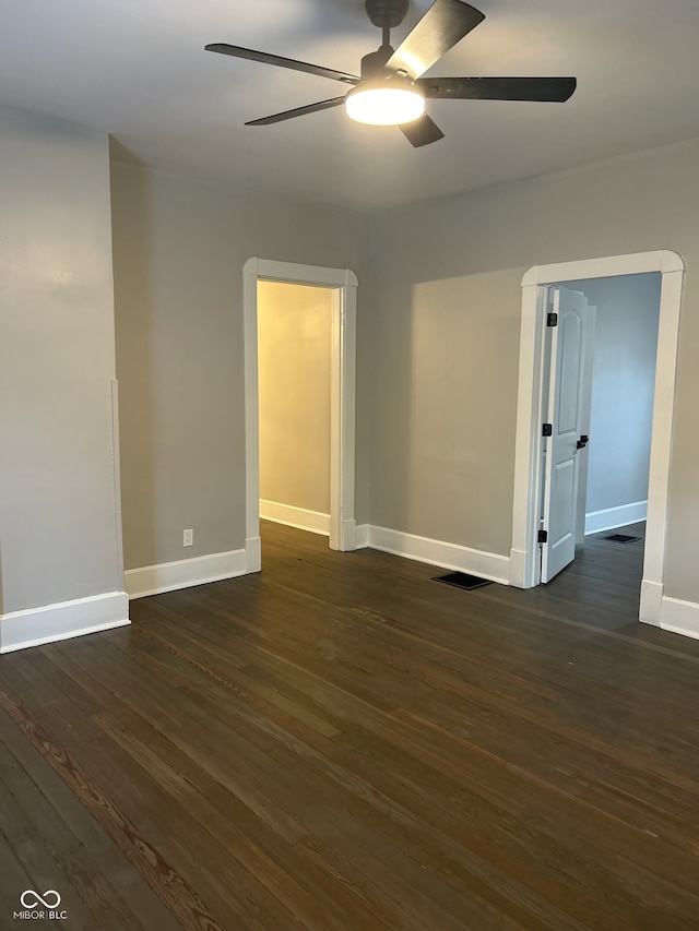 empty room featuring ceiling fan and dark hardwood / wood-style flooring