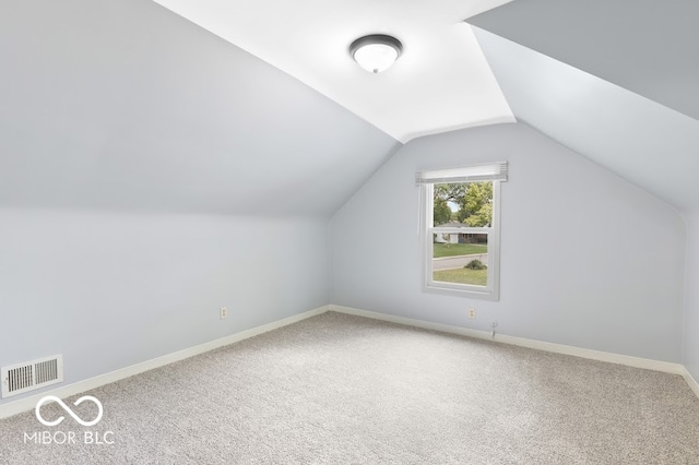 additional living space with carpet flooring and lofted ceiling