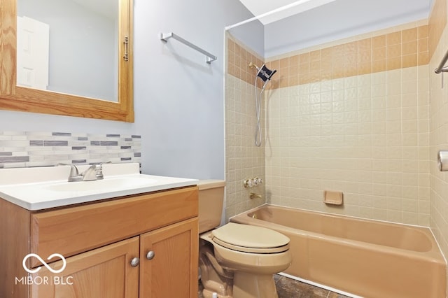 full bathroom featuring tiled shower / bath, vanity, decorative backsplash, and toilet