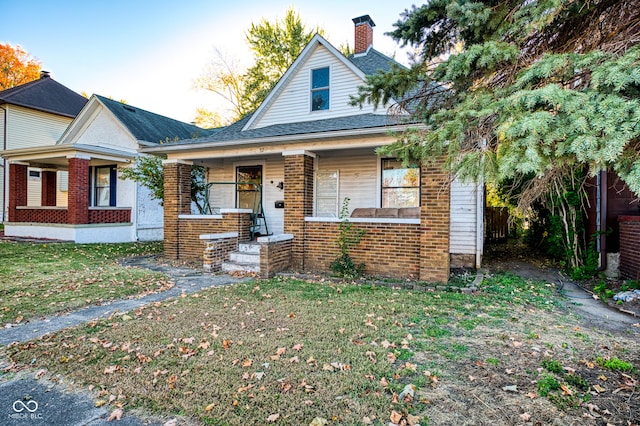 52 Home Ave, Terre Haute, IN 47803 - bungalow with brick siding, a front yard, a chimney, a porch, and roof with shingles