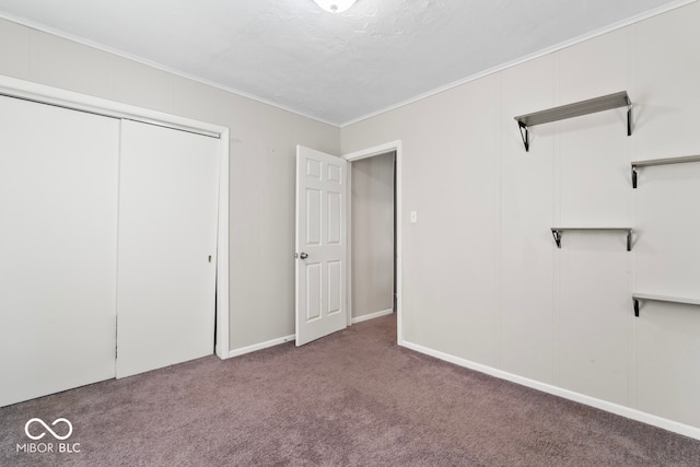 unfurnished bedroom with a closet, carpet, and crown molding