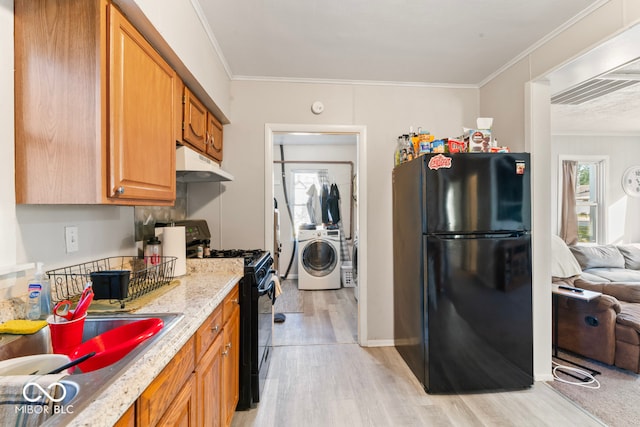 kitchen with washer / dryer, light hardwood / wood-style flooring, sink, black appliances, and crown molding