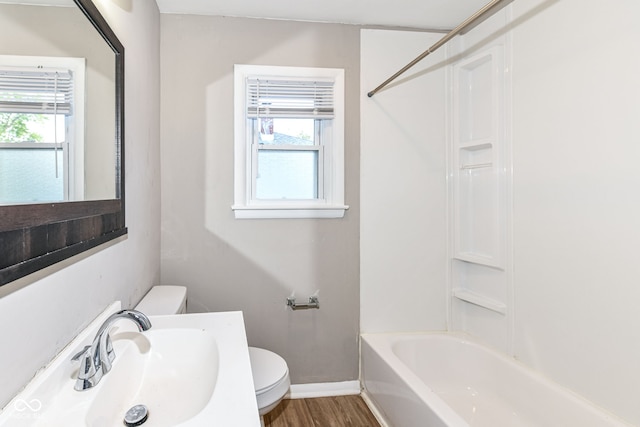 full bathroom with hardwood / wood-style flooring, toilet, shower / bath combination, and sink