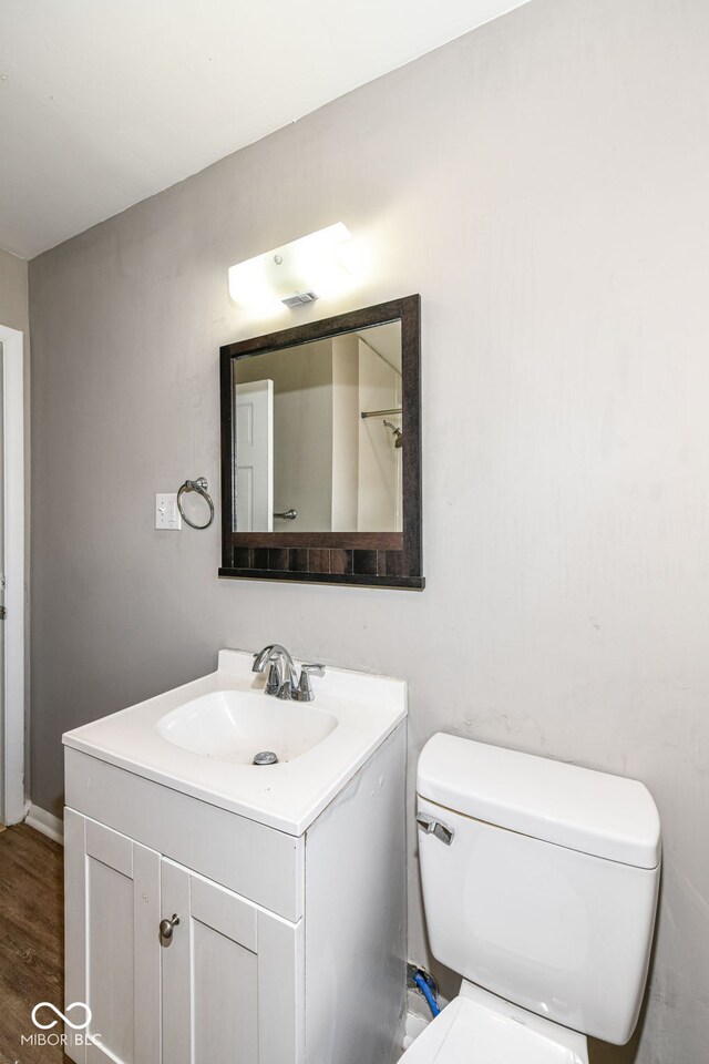 bathroom featuring toilet, hardwood / wood-style flooring, and vanity