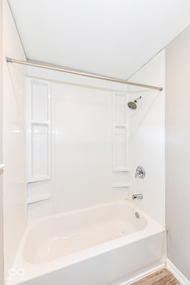 bathroom with shower / bathing tub combination and hardwood / wood-style flooring