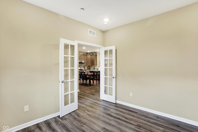 unfurnished room with french doors and dark wood-type flooring