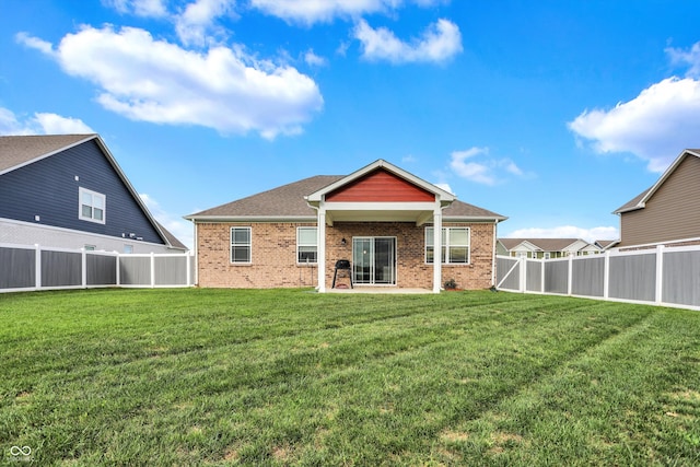 rear view of property featuring a lawn