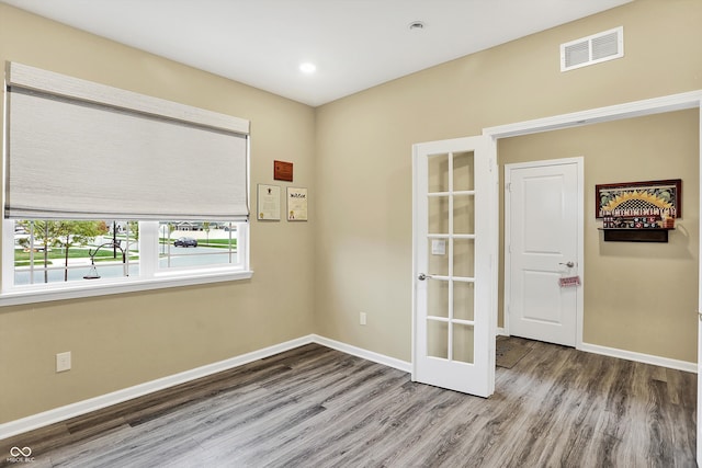 empty room featuring french doors and hardwood / wood-style flooring