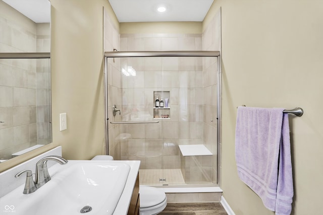 bathroom with vanity, hardwood / wood-style flooring, toilet, and walk in shower