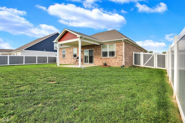 rear view of property featuring a patio and a lawn