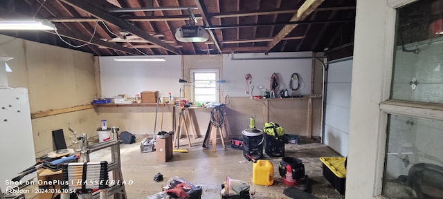 basement featuring white fridge and a workshop area