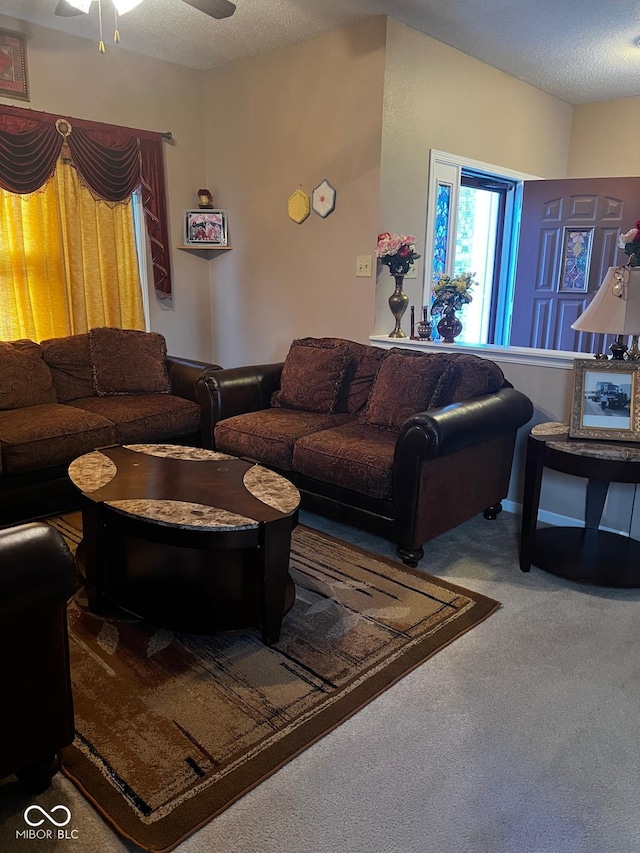 carpeted living room with ceiling fan and a textured ceiling