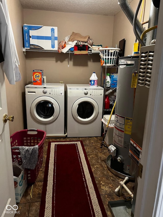 laundry area with washing machine and dryer, gas water heater, and a textured ceiling