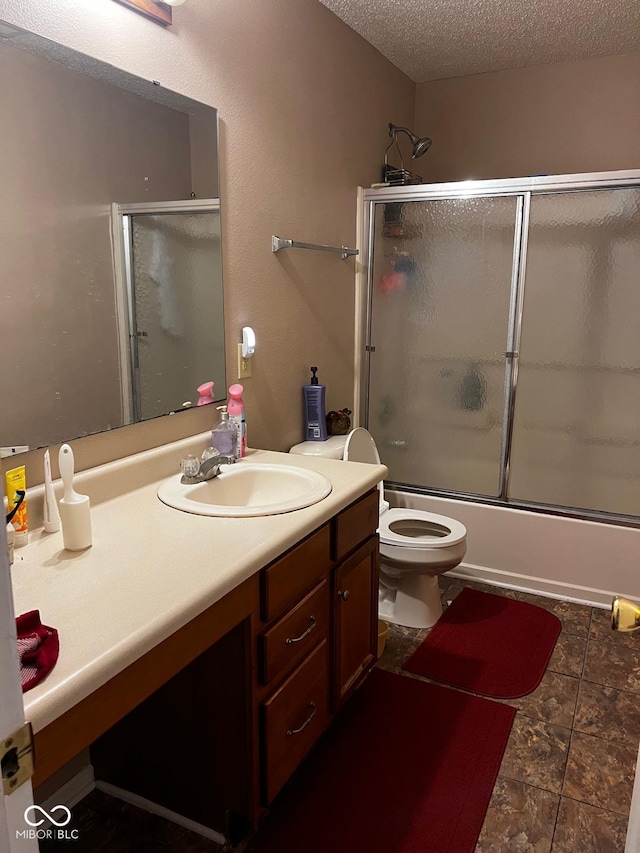 full bathroom with vanity, bath / shower combo with glass door, tile patterned flooring, toilet, and a textured ceiling