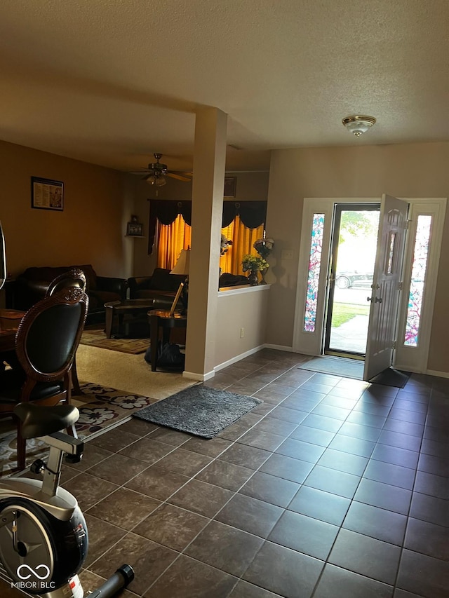 tiled foyer featuring a textured ceiling and ceiling fan