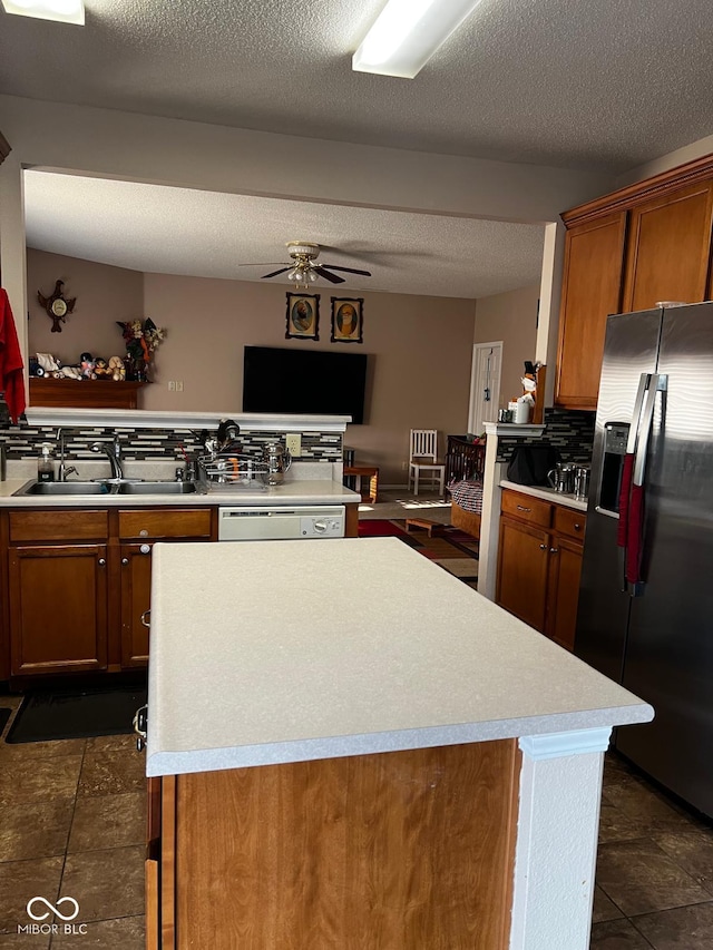 kitchen featuring ceiling fan, stainless steel refrigerator with ice dispenser, sink, and a textured ceiling