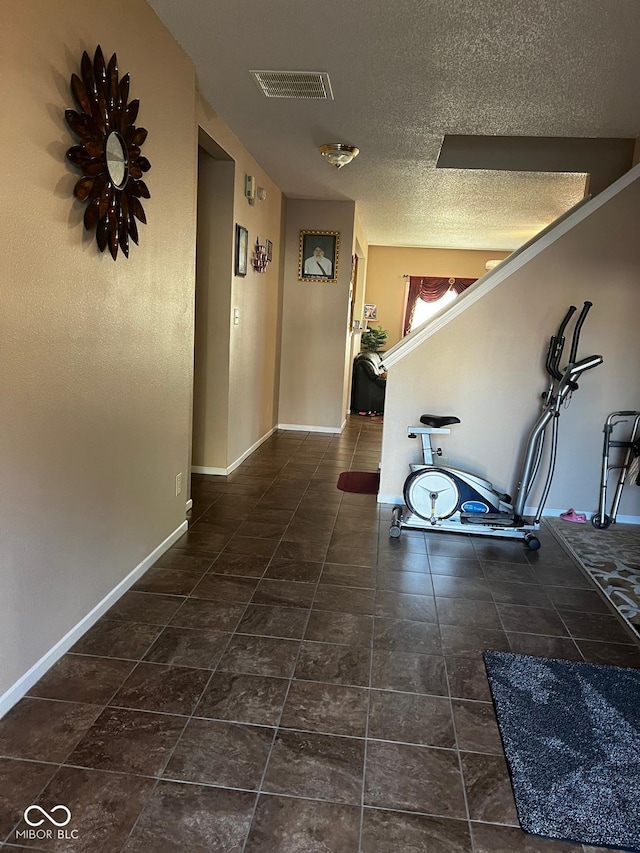 hall featuring a textured ceiling