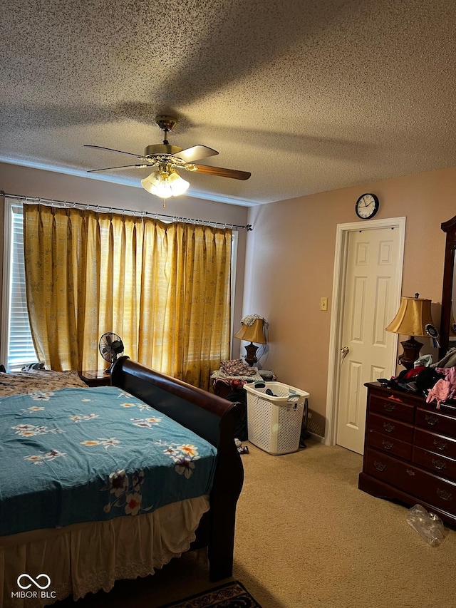 carpeted bedroom with ceiling fan and a textured ceiling