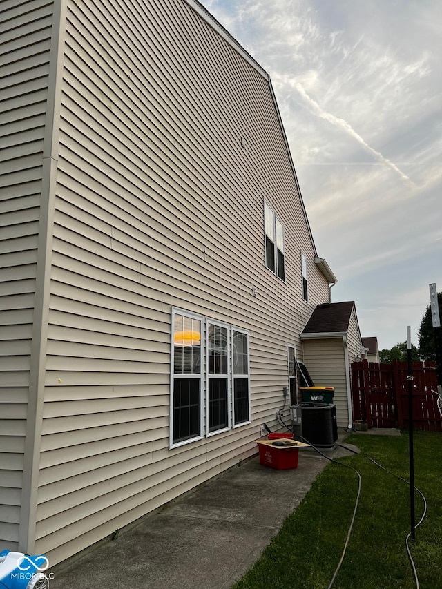 view of home's exterior with a yard, cooling unit, and a patio