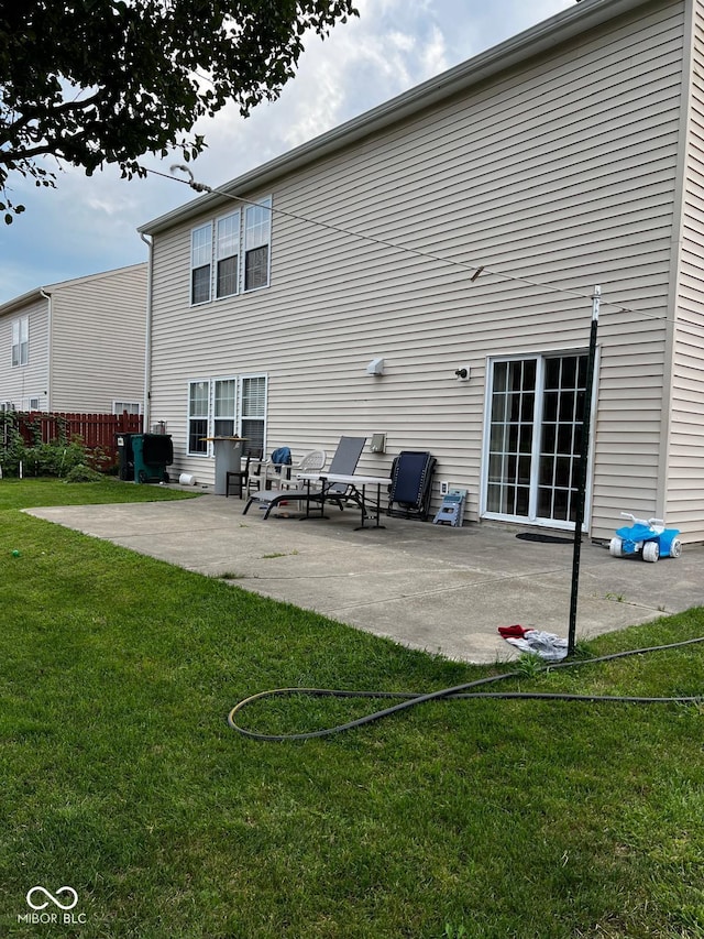 back of house featuring a lawn and a patio