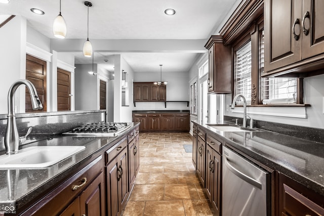 kitchen featuring dark brown cabinetry, decorative light fixtures, sink, and stainless steel appliances