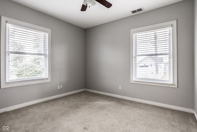 carpeted spare room with ceiling fan and a healthy amount of sunlight