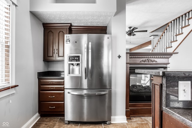 kitchen featuring stainless steel refrigerator with ice dispenser, dark brown cabinetry, and ceiling fan