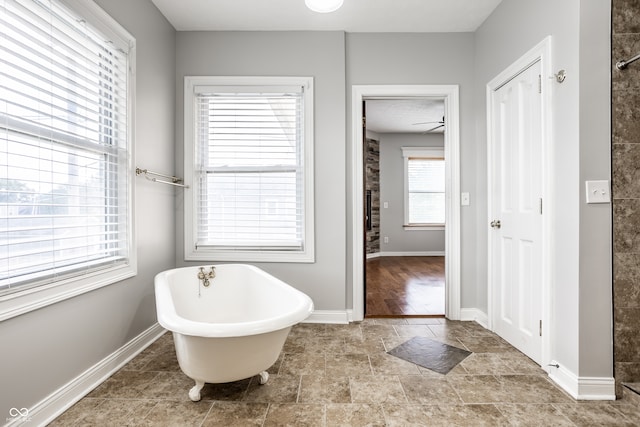 bathroom with ceiling fan and a washtub