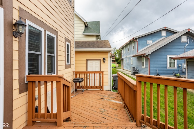 wooden terrace with central air condition unit, a yard, and grilling area