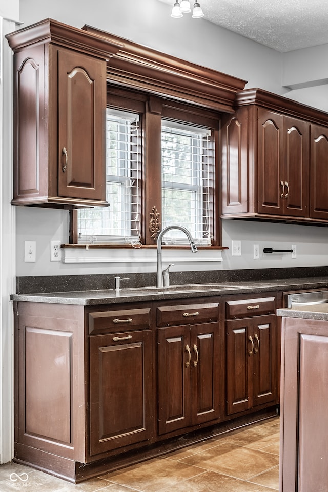 kitchen with dark brown cabinetry and a textured ceiling