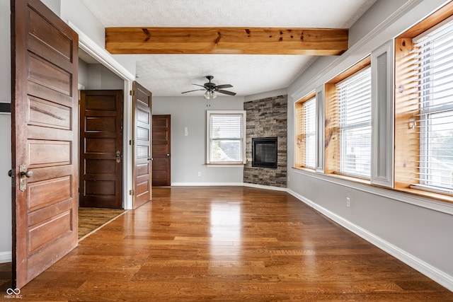 unfurnished living room featuring ceiling fan, hardwood / wood-style flooring, a wealth of natural light, and a textured ceiling