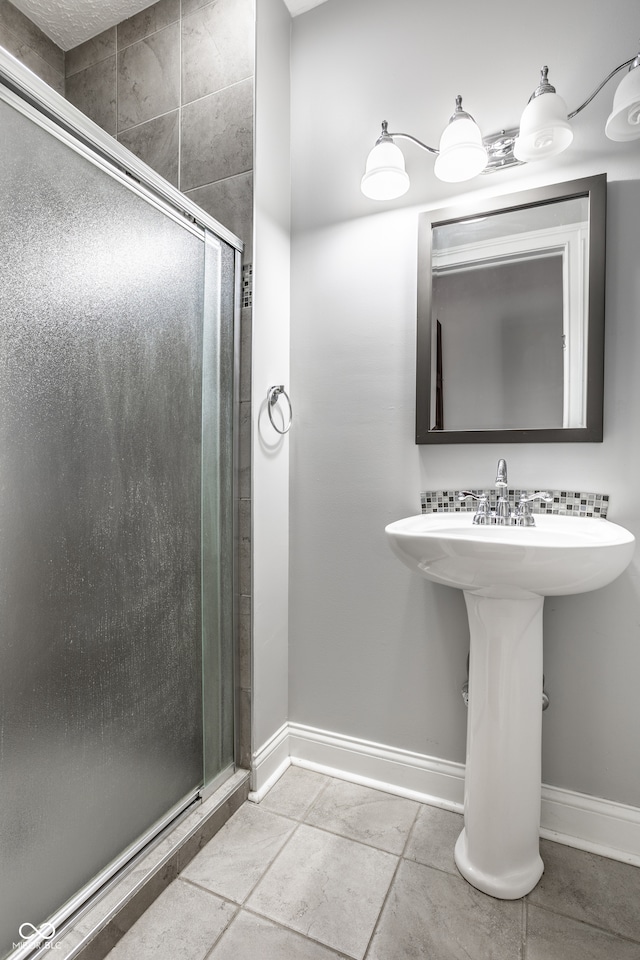 bathroom with tile patterned floors, an enclosed shower, and sink