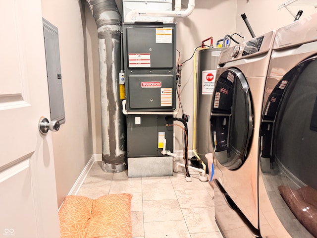 utility room featuring electric panel, heating unit, and washing machine and clothes dryer