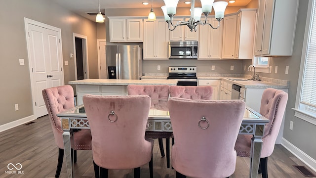 kitchen with sink, decorative light fixtures, a center island, stainless steel appliances, and a breakfast bar