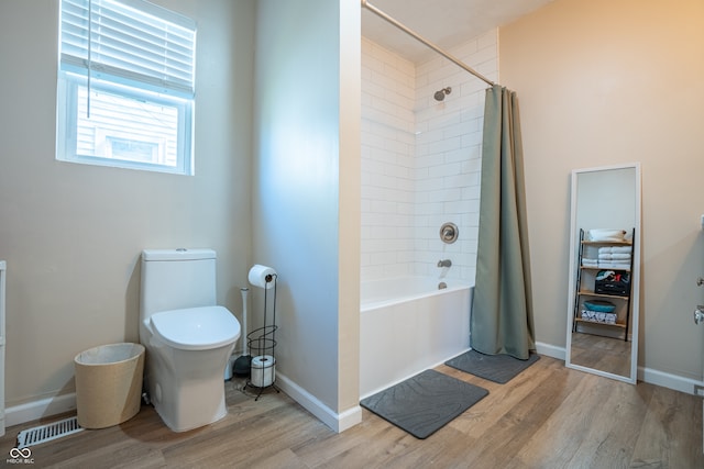 bathroom featuring shower / bath combination with curtain, wood-type flooring, and toilet