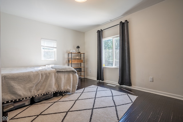 bedroom with dark hardwood / wood-style floors