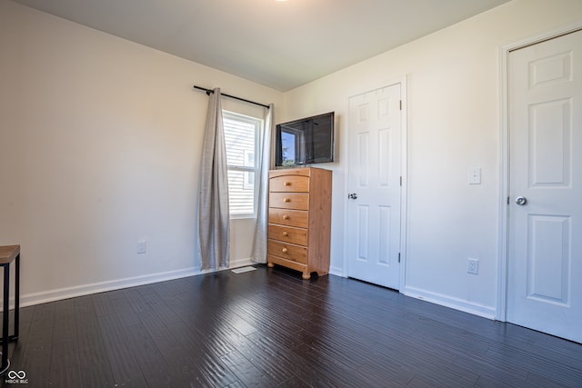 unfurnished bedroom with dark wood-type flooring