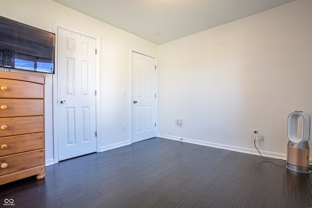 unfurnished bedroom with dark wood-type flooring