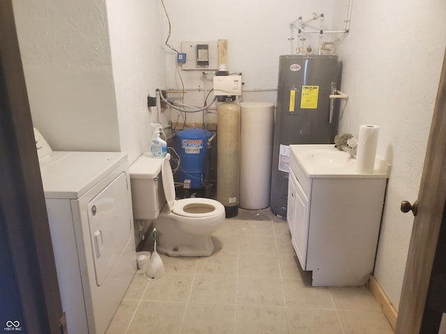 bathroom with washer / clothes dryer, water heater, toilet, vanity, and tile patterned flooring