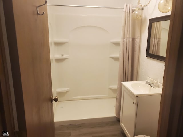 bathroom featuring vanity, shower / bathtub combination with curtain, and hardwood / wood-style floors