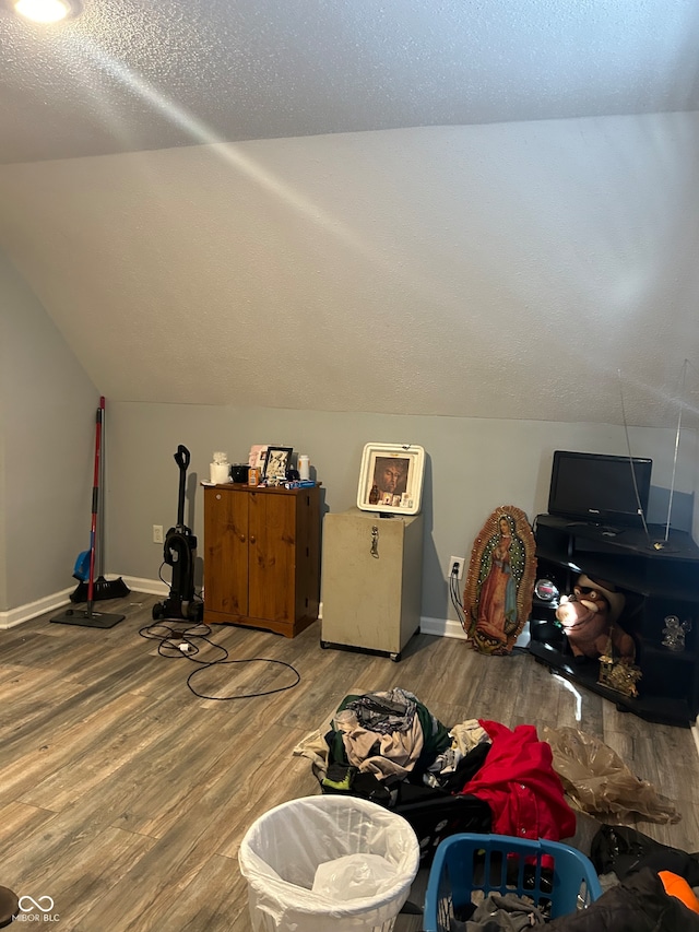 bonus room with hardwood / wood-style floors, a textured ceiling, and vaulted ceiling