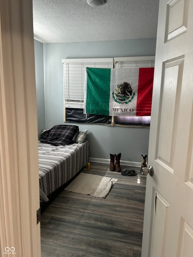 bedroom featuring a textured ceiling and wood-type flooring