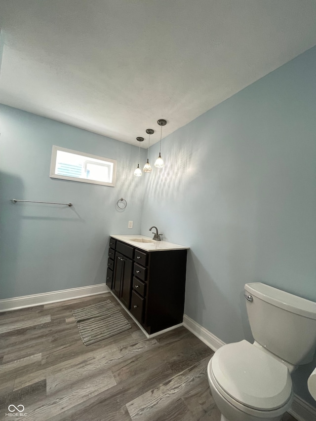 bathroom with wood-type flooring, vanity, and toilet