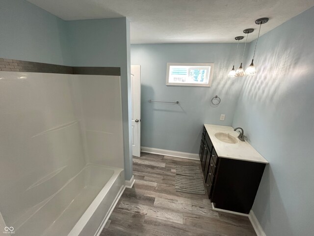 bathroom featuring hardwood / wood-style floors, bathing tub / shower combination, and vanity