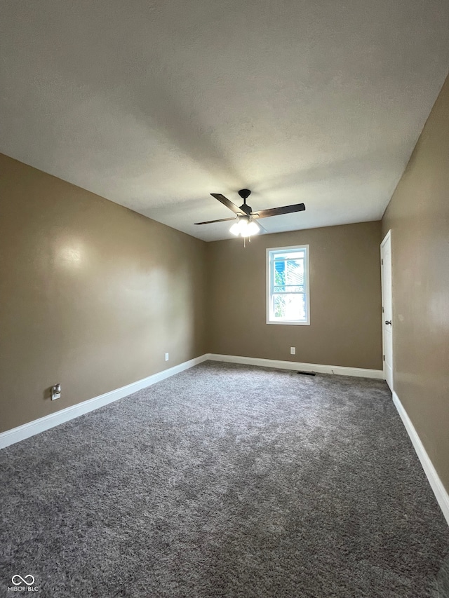 carpeted empty room with ceiling fan and a textured ceiling