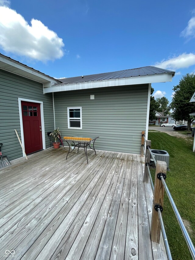 wooden terrace featuring a lawn