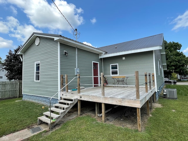 back of property with a wooden deck, cooling unit, and a lawn