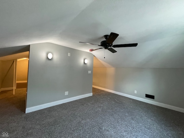 bonus room featuring ceiling fan, vaulted ceiling, and dark carpet