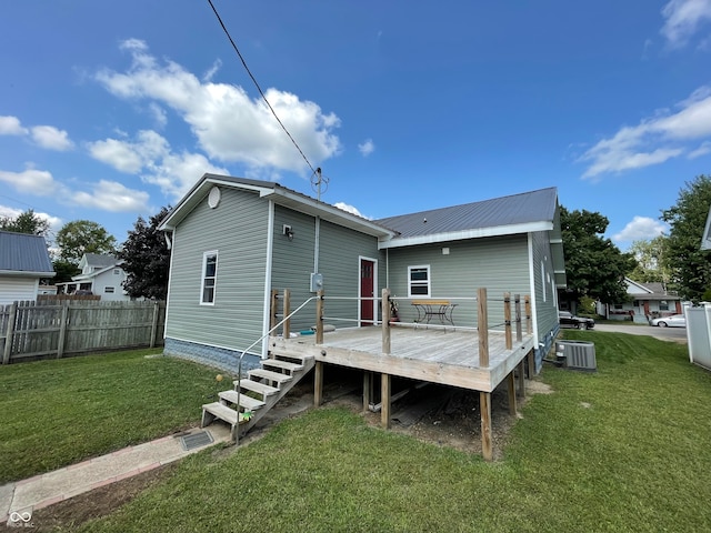 back of house featuring a wooden deck, cooling unit, and a lawn