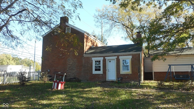 rear view of property featuring a lawn